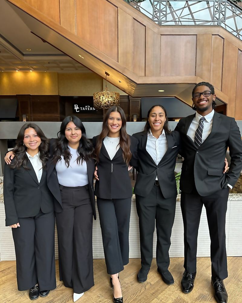 Five Social Standard team members in business dress in a hotel lobby