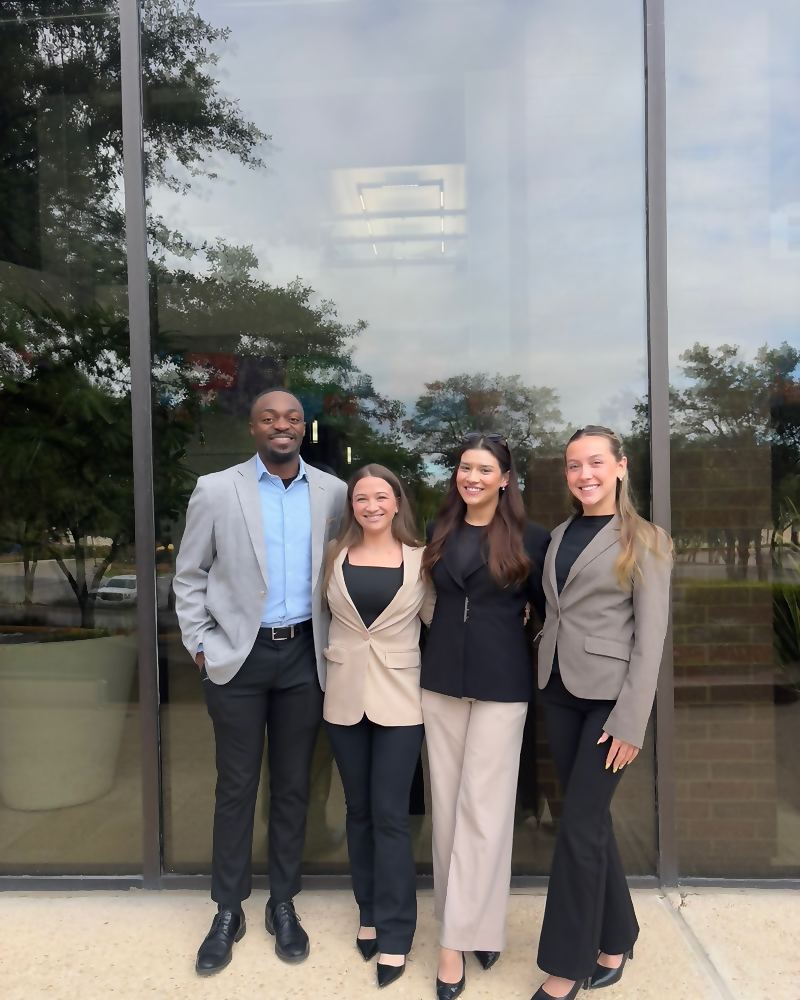 Four Social Standard representatives outside a glass-fronted building