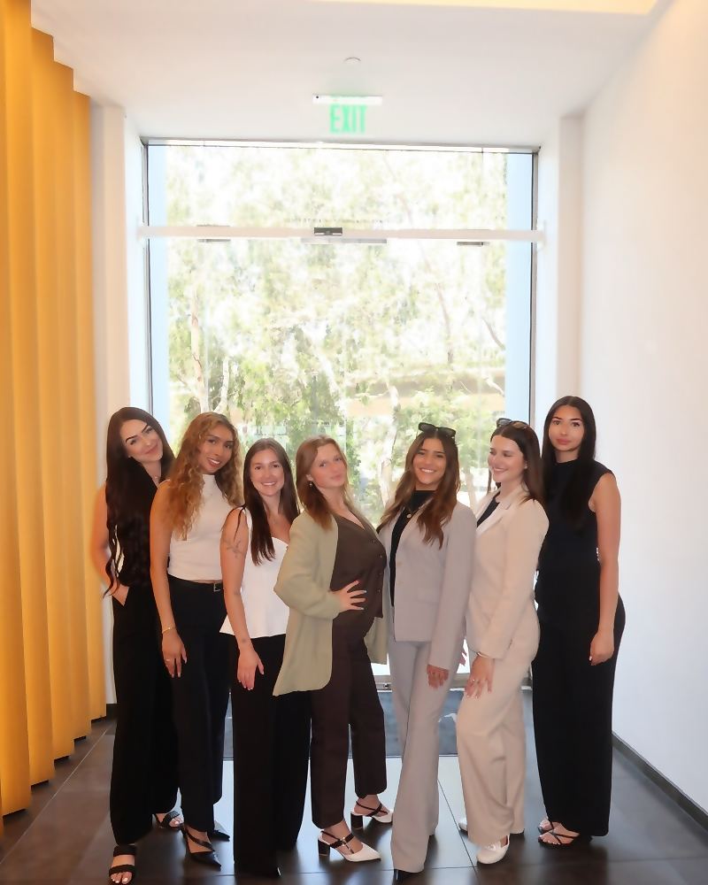 Eight members of the Social Standard team together in a bright office corridor